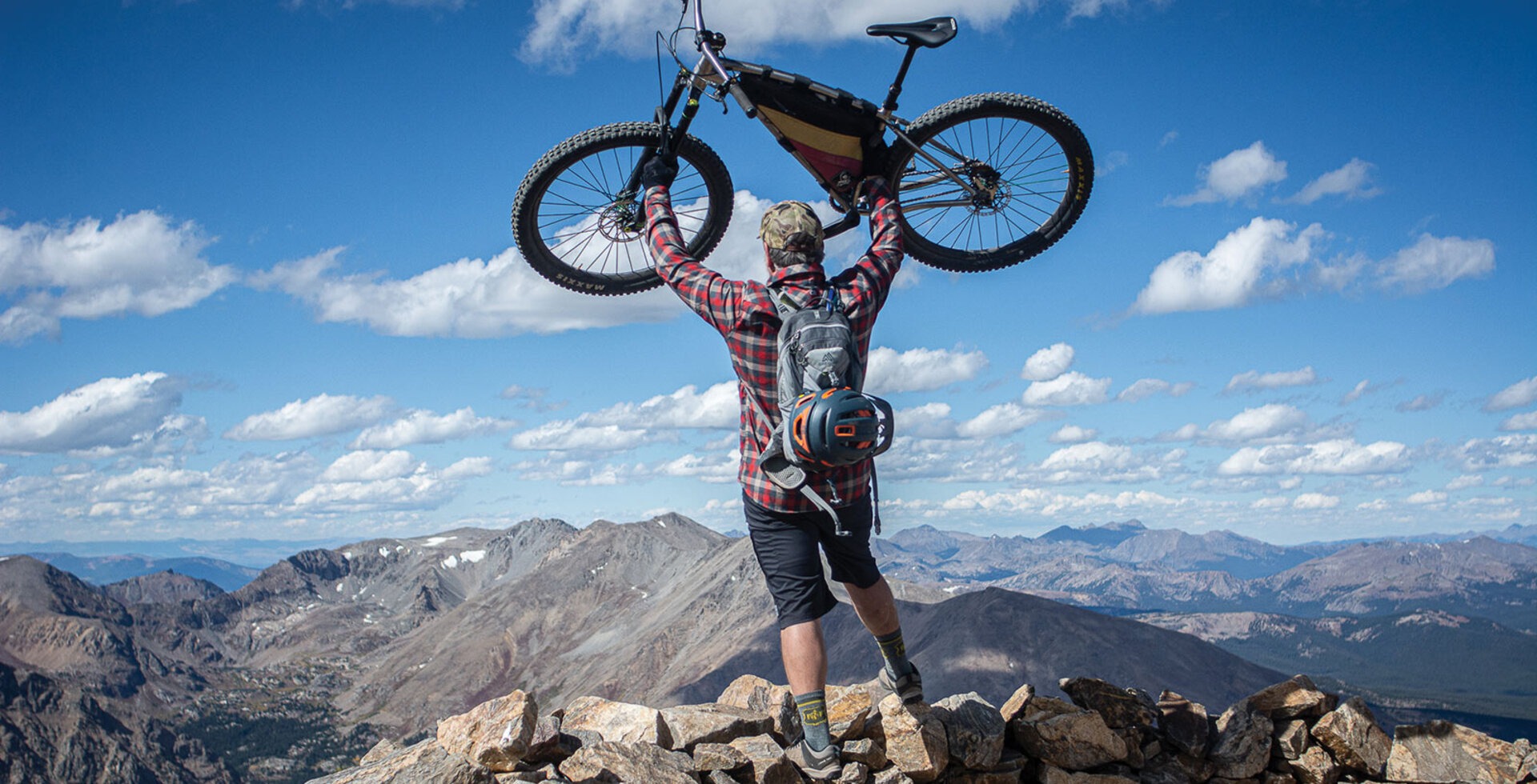 The author, Chris Reichel, heaves his trusty singlespeed above his head after reaching the top of Mount Elbert. Photo: Liz Sampey