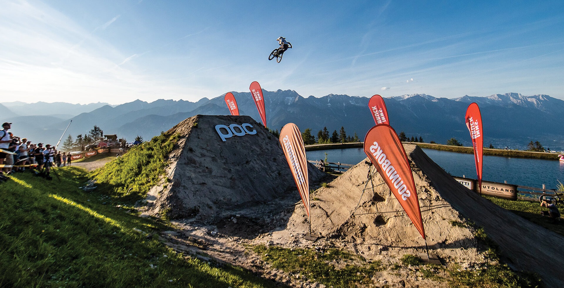 Robin Goomes soars across a massive gap at the 2021 Crankworx World Tour in Innsbruck, Austria. Goomes’ career is full of twists— growing up in the rugged Chatham Islands, time spent in Antarctica, and eventually making the leap to professional mountain biker. Photo: Sven Martin