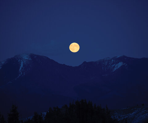 A full moon crests over mountains in western Canada. For years, a small crew of riders and filmmakers have worked to quietly tell the story of how they relate to spending time in some of North America’s most remote mountains.