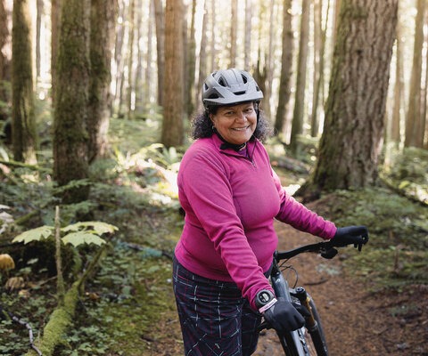 Moniera Khan delights in riding amidst Squamish’s lush forests. Whether she’s braving the winter weather during training or pausing to admire charming fungi along the forest paths, Moniera simply enjoys being on her bike.