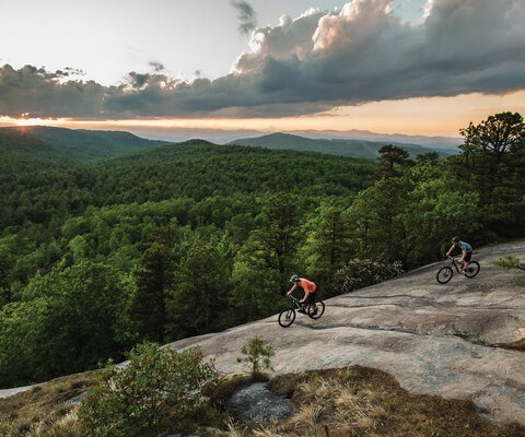 A geological joyride. Dan Ennis and Evan Voss ride Big Rock trail in DuPont State Forest with the Blue Mountains stretching off into the distance.