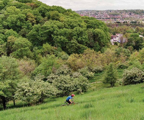 Anna Barensfeld takes in the view of Homestead, a town located just across the Monongahela River from Pittsburgh, as she rides High Traverse at the southern end of Frick Park’s trail system. Stacks from old mills remain as historical landmarks in the area though the factories of Henry Clay Frick’s empire are long gone.