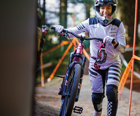Caroline Buchanan walks her bike up for another run at the 2024 edition of Crankworx Rotorua in New Zealand. Buchanan credits the Crankworx series for rewarding mountain bikers who focus on more than one discipline.